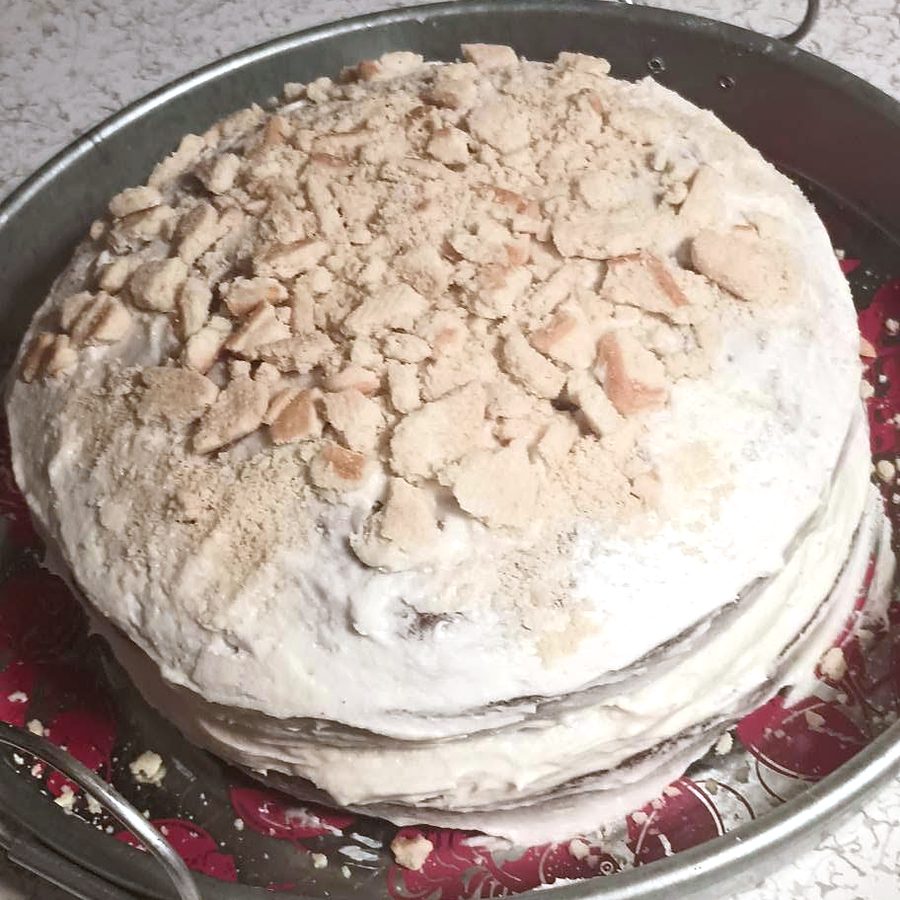 Round frosted cake with a toasted topping by Joyeful Treats