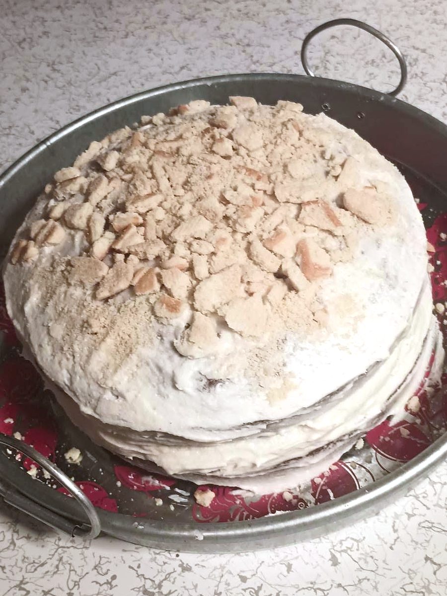 Round frosted cake with a toasted topping by Joyeful Treats